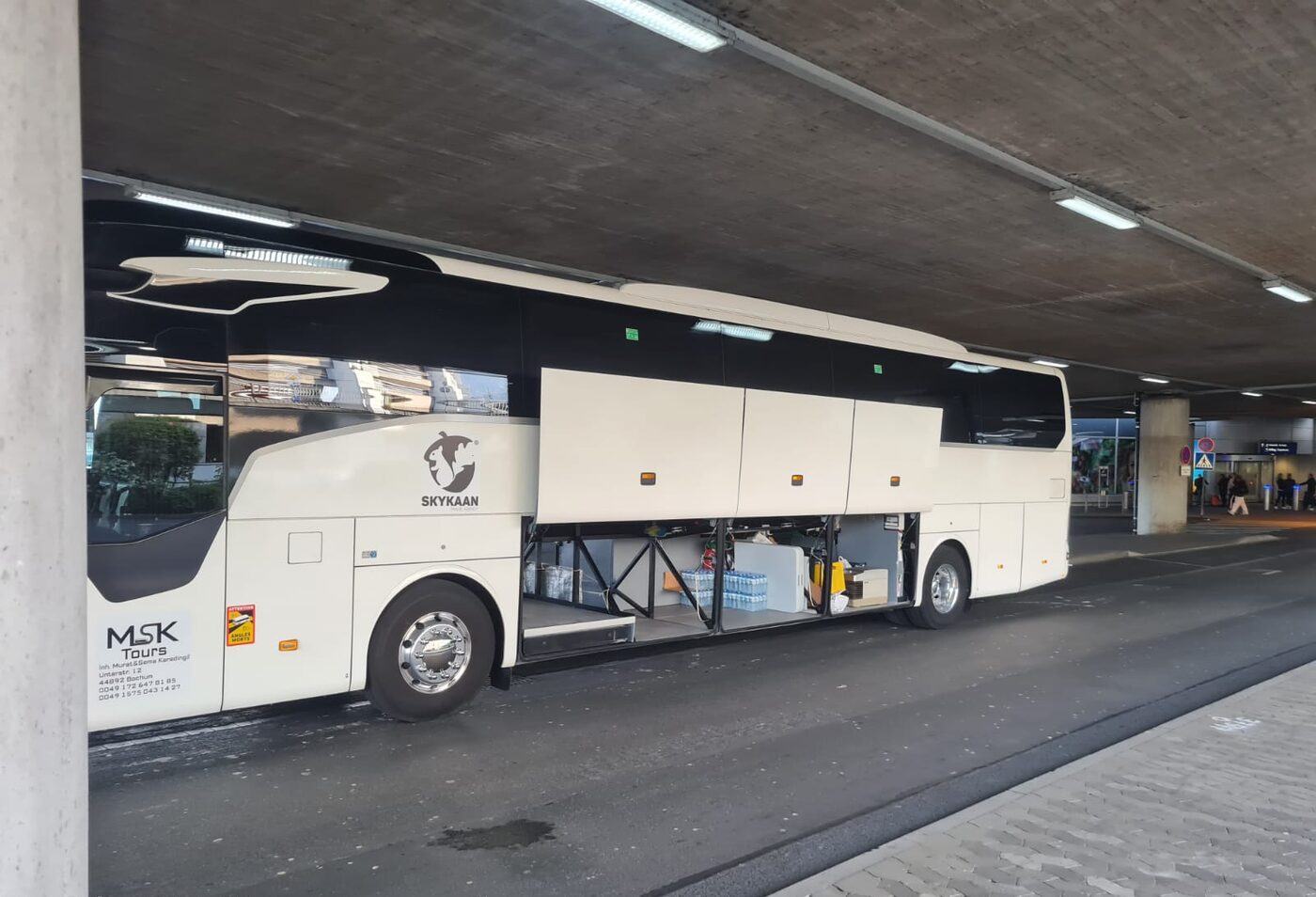 Seitenansicht des MSK Tours Reisebusses mit geöffnetem Gepäckraum